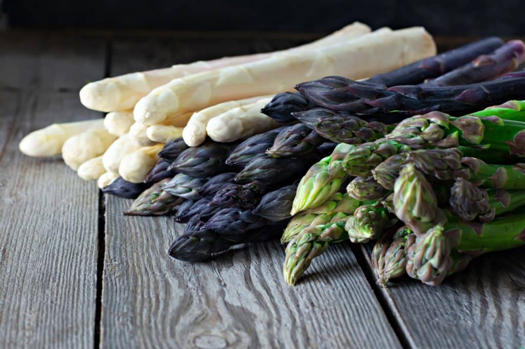 A picture of green, purple, and white asparagus for the blog post 'Can hamsters eat asparagus'